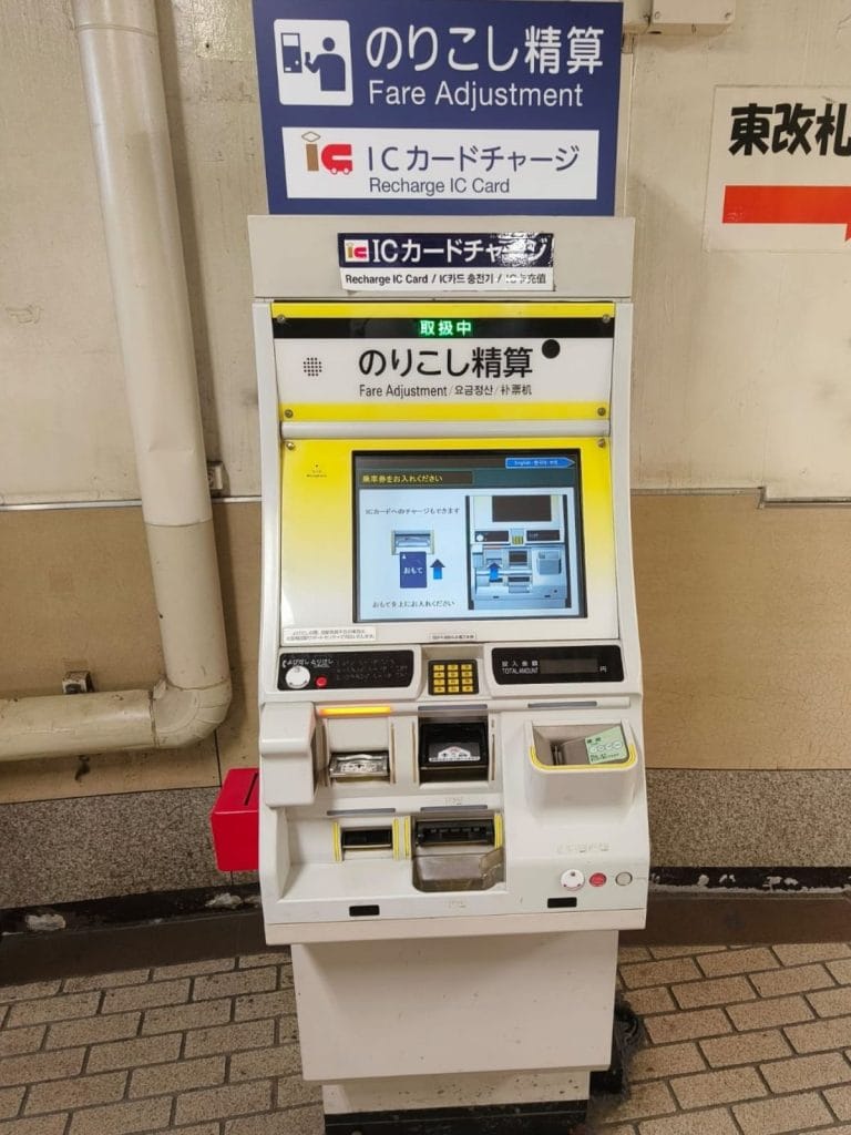 Japanese fare adjustment machine for ICOCA and IC cards inside a train station, used to top up balance after insufficient fare at exit gates