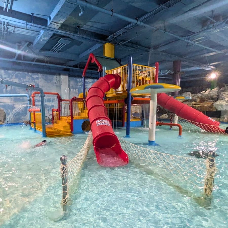 Indoor kids splash zone at Splash Inn Waterpark, Kenting, with colourful slides and shallow pools.