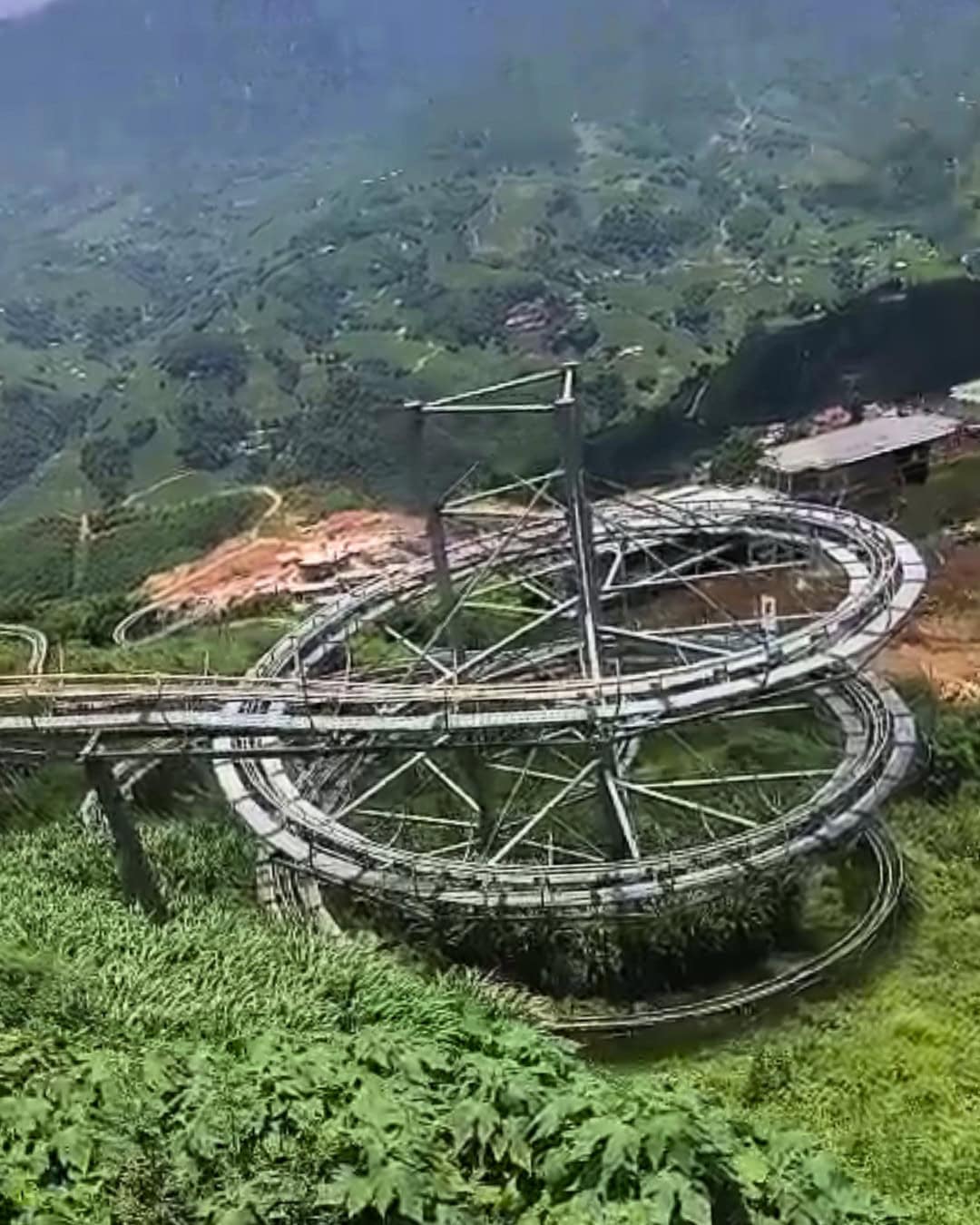Spiral alpine coaster winding down a lush hillside in Sapa, Vietnam.