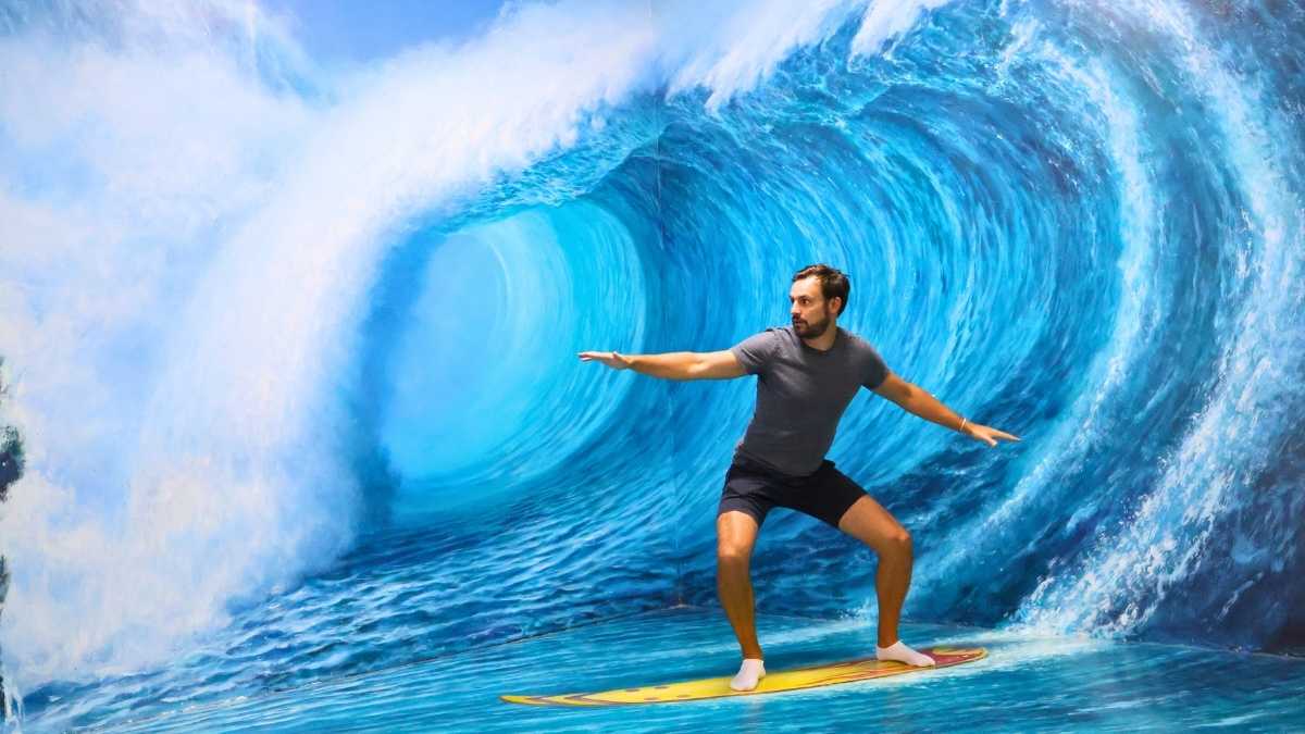 Visitor posing on a 3D surfing illusion at Art in Paradise Museum Da Nang