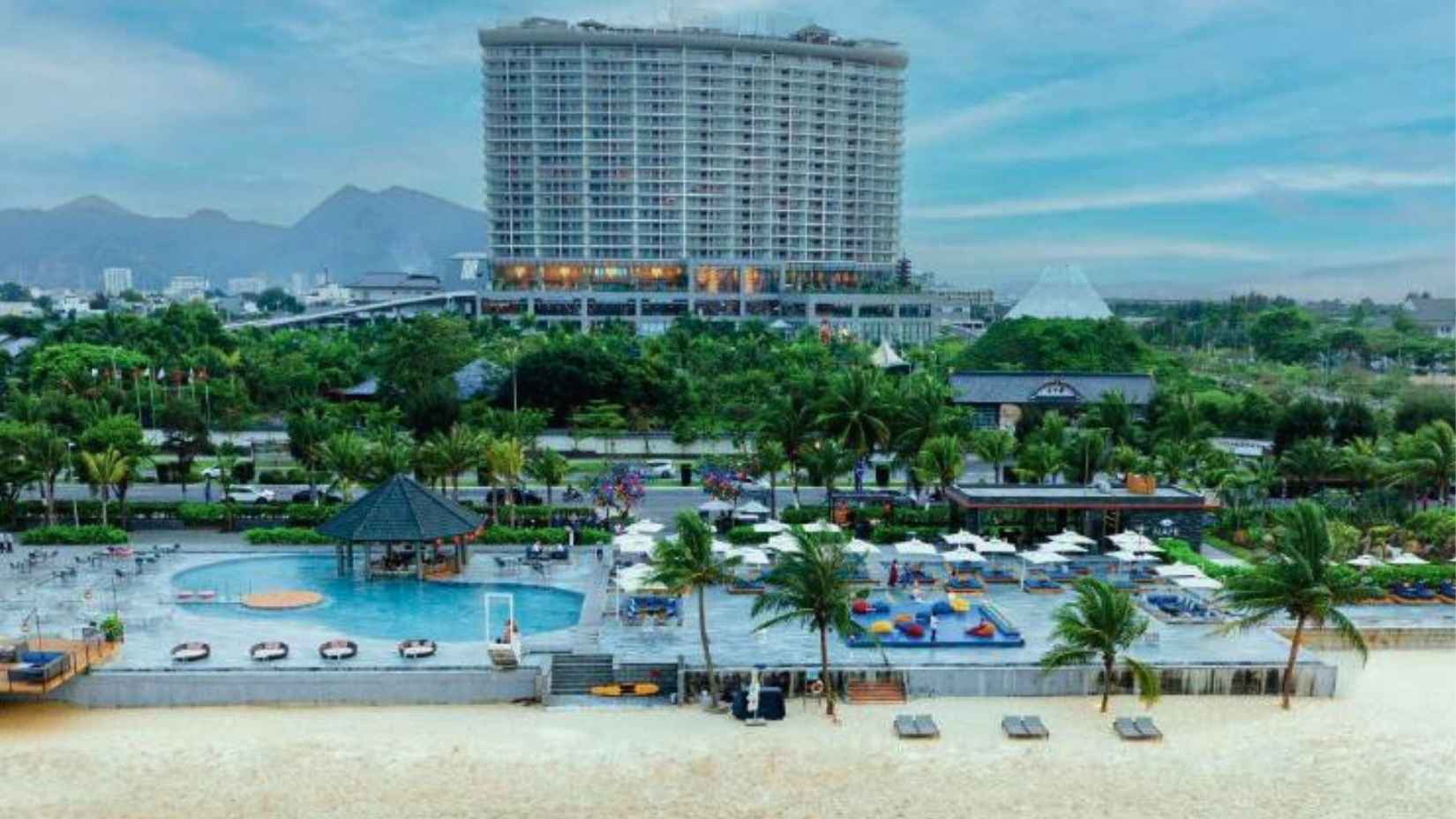 Da Nang Mikazuki Japanese Resorts & Spa beachfront with swimming pools, sun loungers, and the main hotel building in the background.