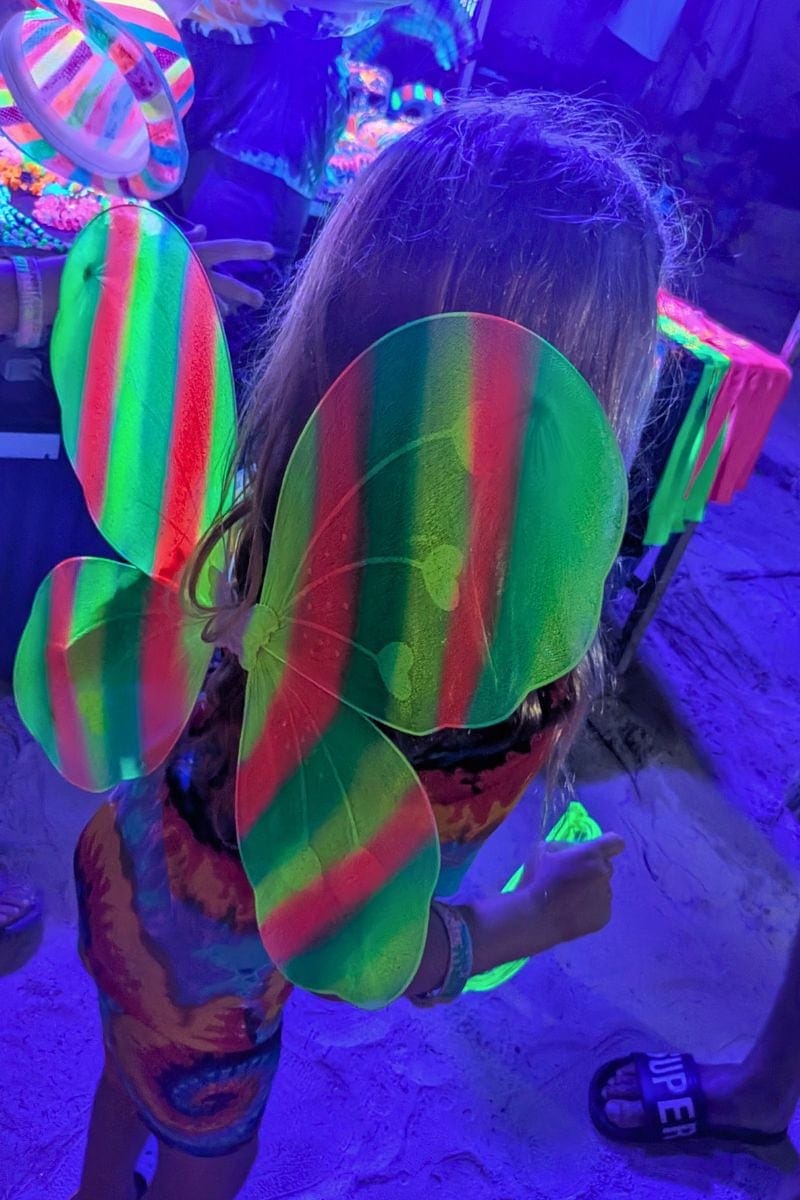 Young child wearing glowing butterfly wings at the Full Moon Party