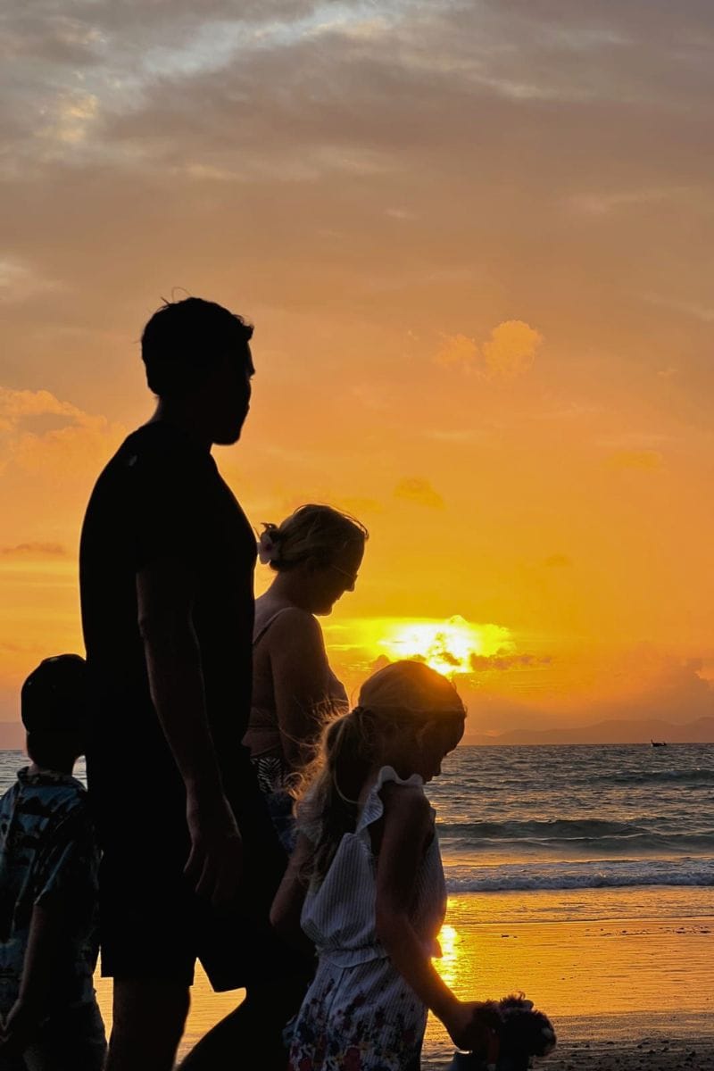 Family walking on Railay Beach with kids at sunset in Thailand